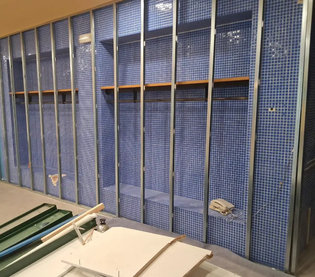 Reforma de baño con estructura metálica para trasdosado sobre pared de gresite azul en Barcelona